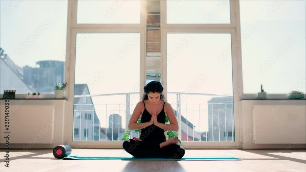 Young woman with black hair in leggins doing yoga excersices at home in loft studio available sun light shot in 4k Young woman with black hair in leggins doing yoga excersices at home in loft studio available sun light shot in 4k