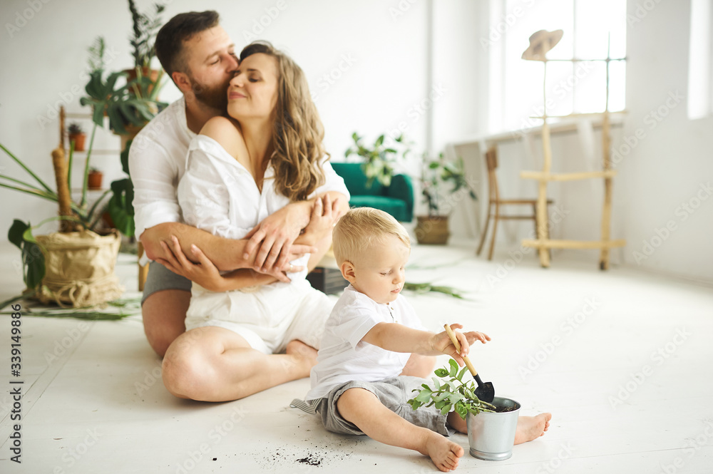 Happy family working at home. Transplanting plants with their child