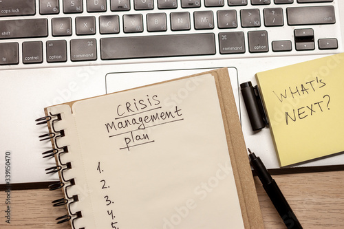 crisis management plan written words in notebook photo