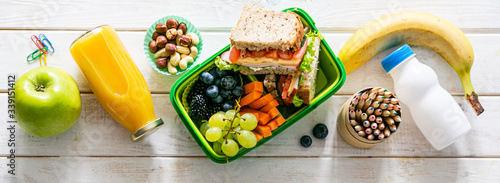 фотографія Back to school concept - lunch box with juice, apple and banana, copy space