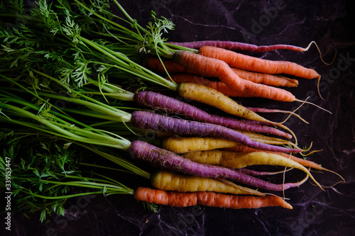 Colorful carrots, healthy vegetables on a black marble background