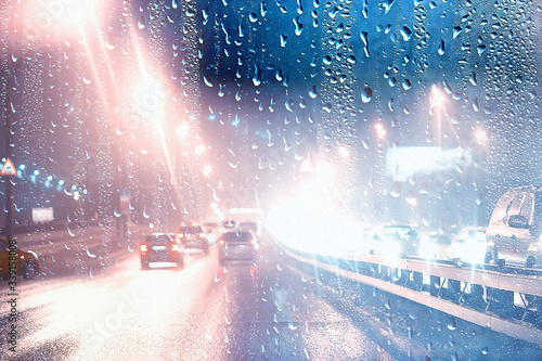 drops on glass auto road rain autumn night   abstract autumn background in the city  auto traffic  romantic trip by car