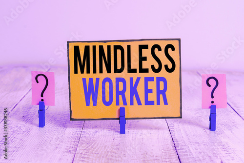 Word writing text Mindless Worker. Business photo showcasing Having no intelligent purpose Showing little attention Scribbled and crumbling sheet with paper clips placed on the wooden table photo