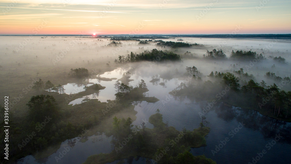 sunrise over the fog clad peat bog and lake landscape in Estonia