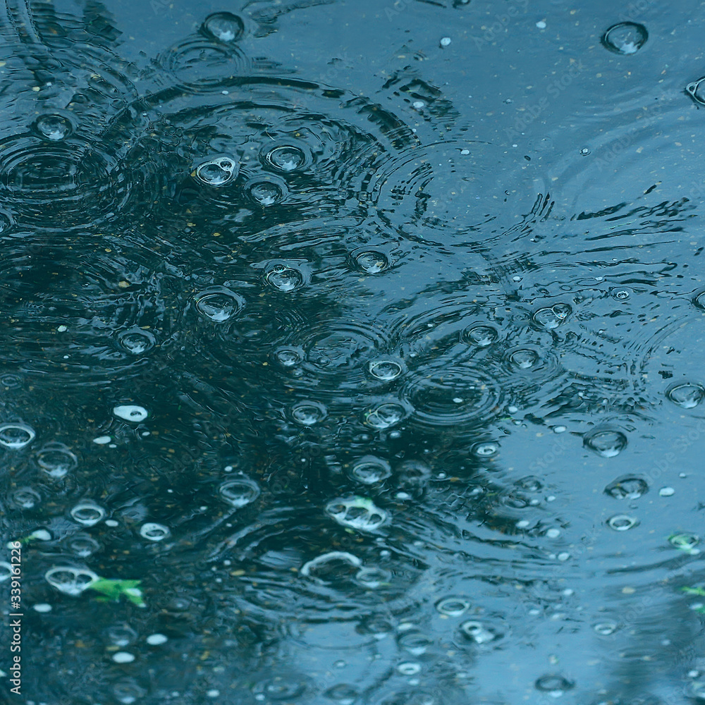 blue background puddle of rain / raindrops, circles on a puddle, bubbles in the water, the weather is autumn blue background puddle of rain / raindrops, circles on a puddle, bubbles in the water, the weather is autumn