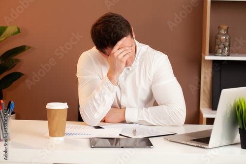 Tired employee working at desk at company office