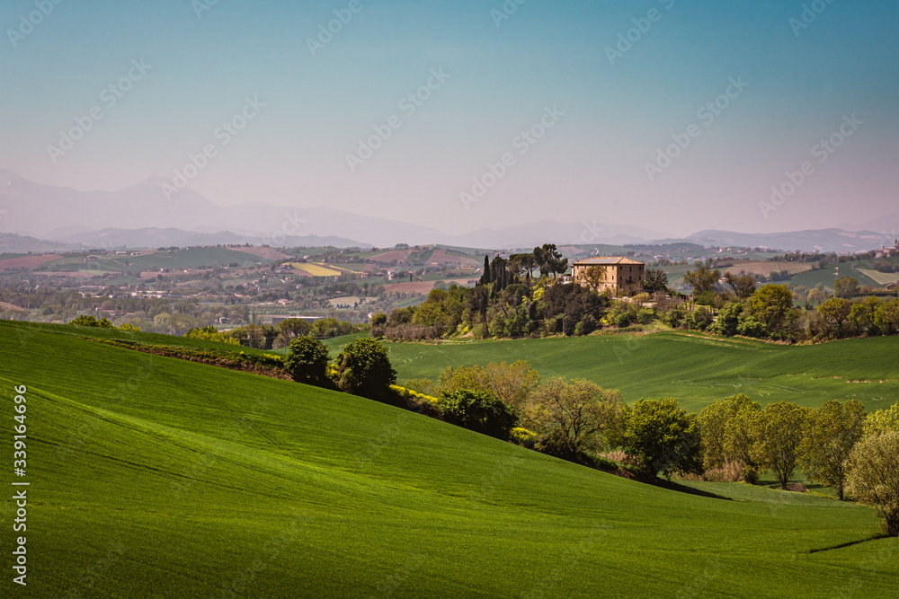 Panorama of the rolling green countryside hills of Passo Ripe, near Senigallia, Le Marche, Italy with the mountains in the distance