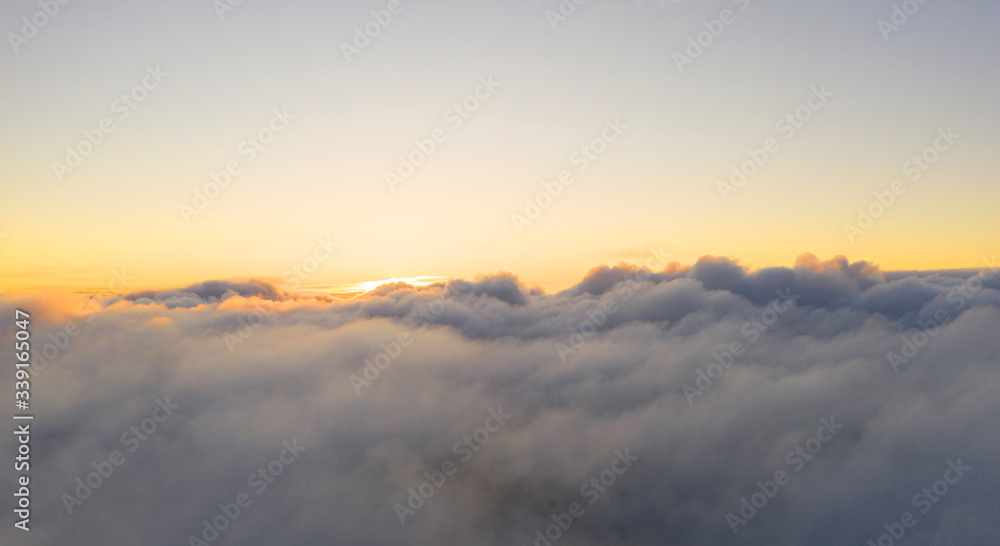 Aerial view clouds. View from drone. Aerial top view cloudscape. Texture of clouds. View from above. Sunrise or sunset over clouds. Panorama clouds