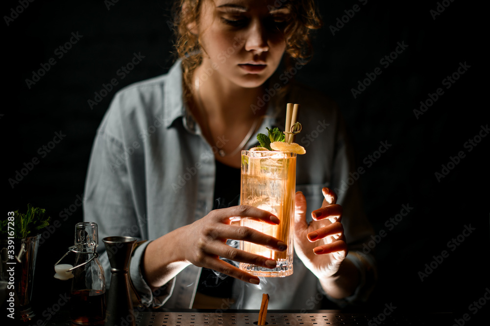 young woman at bar holds beautiful cocktail with ice young woman at bar holds beautiful cocktail with ice