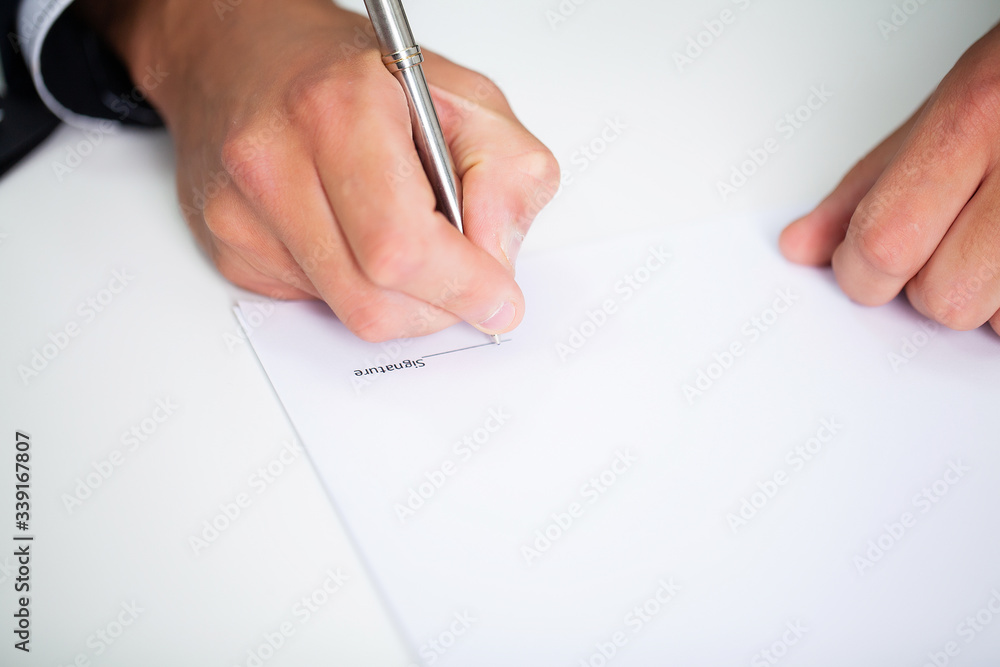 Businessman sitting at office desk signing contract. Businessman sitting at office desk signing contract.