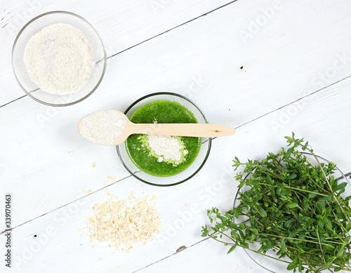 Homemade herb facial mask from  finely ground oat and herb. Common chickweed, Stellaria media for smooth and healthy face. The rest you can eat. Top view, copy space. photo