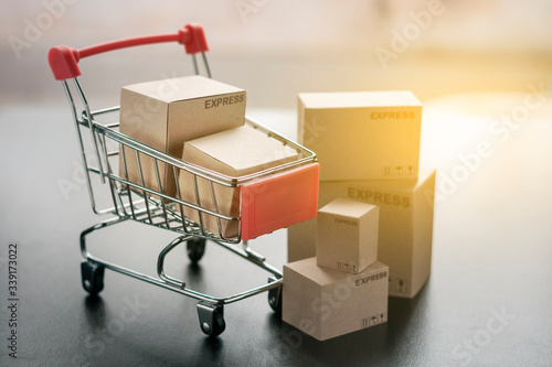 Paper shopping small box express in a shopping cart on dark wood table background. Online shopping concept.