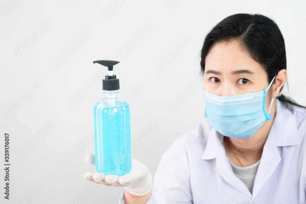 The bottle of alcohol sanitizer cleaner on hand of a nurse or doctor or physician assistant with selective focus The bottle of alcohol sanitizer cleaner on hand of a nurse or doctor or physician assistant with selective focus