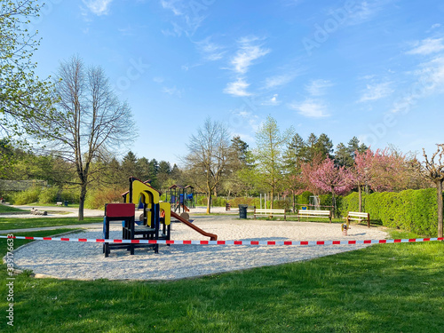 Children's playground in the park is closed and wrapped in alarm caution tape for global coronavirus quarantine. No children on playgrounds in Europe. Prevention of coronavirus COVID-19.