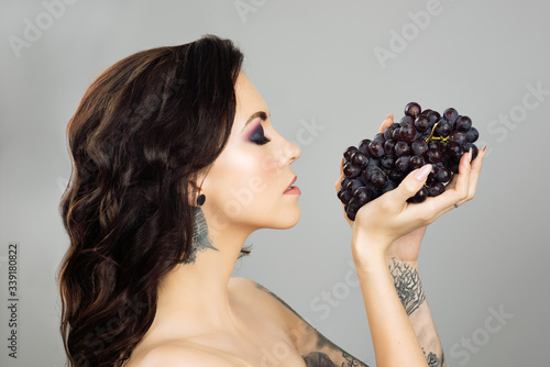 Face of a woman  with blue grapes photo