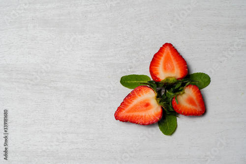 cut strawberries on the table with mint photo