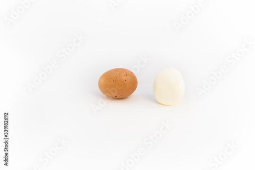 a brown chicken egg and an eggs boiled and peeled