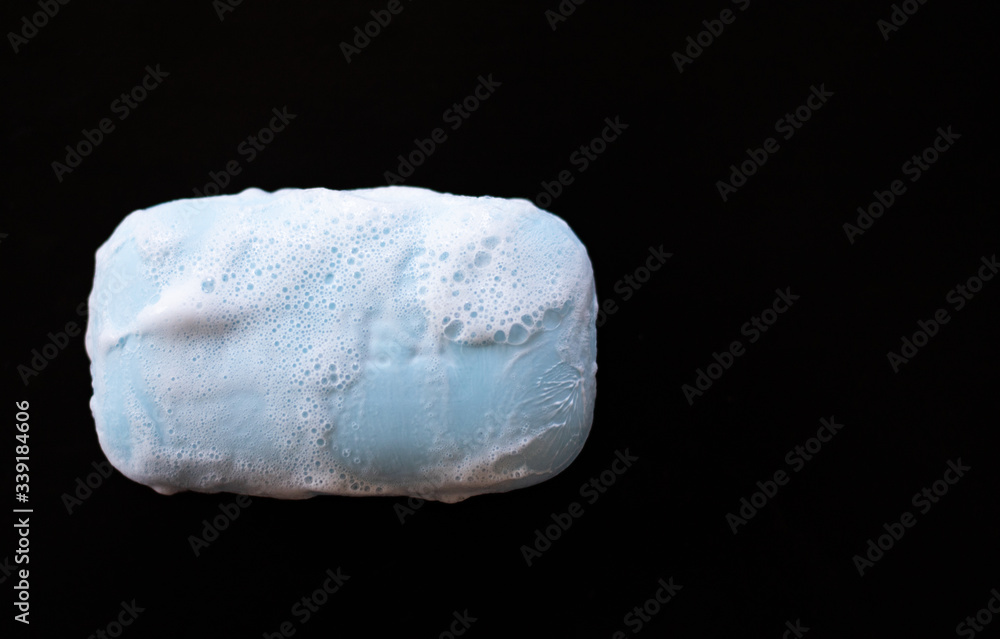 bar of soap with foam bubbles on black background. Top view. bar of soap with foam bubbles on black background. Top view.