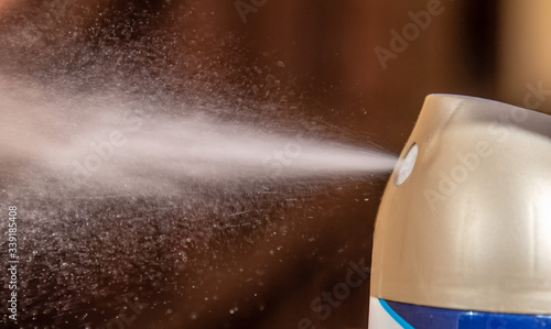 aerosol can sprays air freshener scent into a room