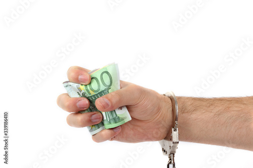 Male hand with handcuffs holding a lot of money photo