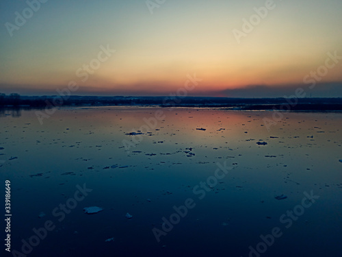 sunset over the river with floating ice floes