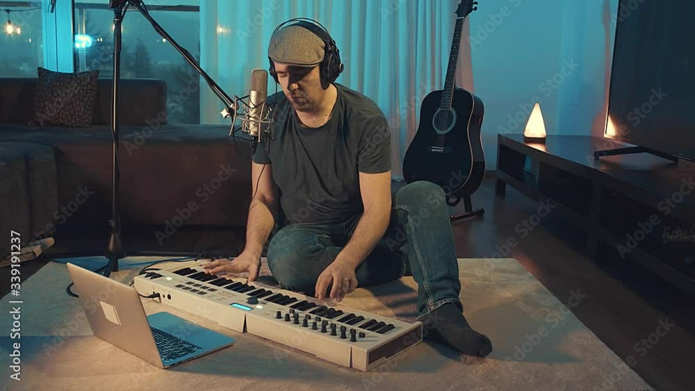 Musician in headphones playing on piano at home sitting on floor at evening time. Music hobby, Create own songs, learning online. 4K video
Musician in headphones playing on piano at home sitting on floor at evening time. Music hobby, Create own songs, learning online. 4K video