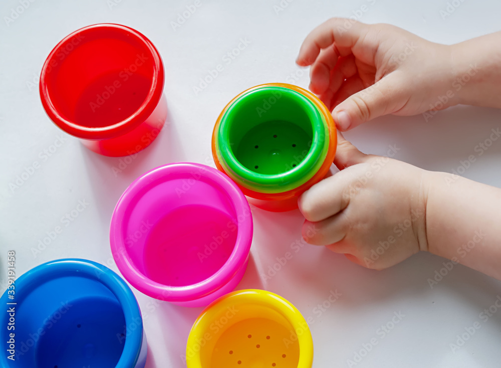 Colorful red, green, yellow, blue, pink and yellow plastic cups and baby pens Colorful red, green, yellow, blue, pink and yellow plastic cups and baby pens