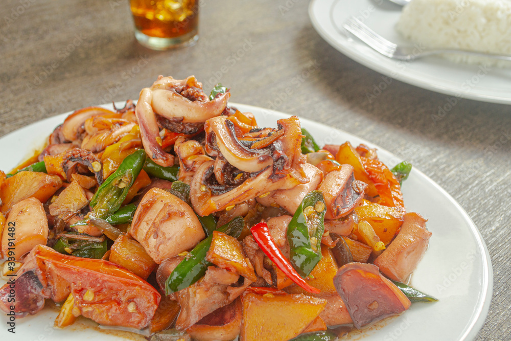 Tumis cumi or stir-fried squid. indonesia food made from squid, garlic, chili and other ingredients. has a savory and spicy taste and has good nutritional content for the body Tumis cumi or stir-fried squid. indonesia food made from squid, garlic, chili and other ingredients. has a savory and spicy taste and has good nutritional content for the body