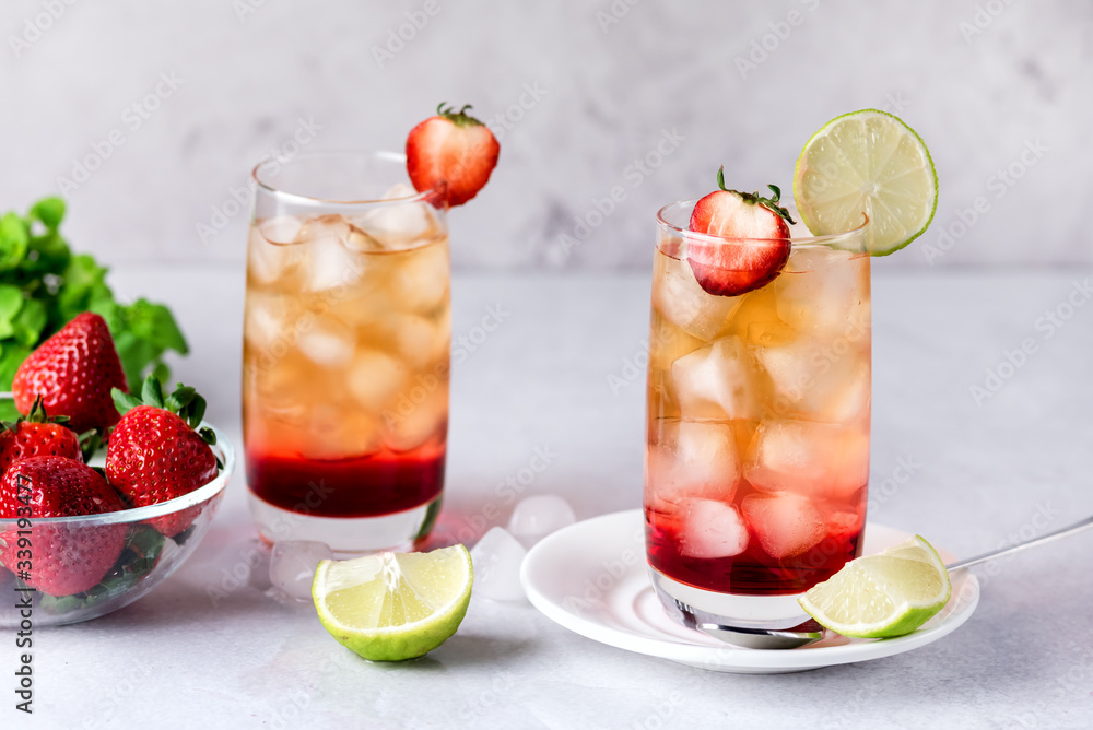 Glasses of Strawberries and Lime Ice Tea Refreshing Healthy Summer Drink Light Gray Background Horizontal Glasses of Strawberries and Lime Ice Tea Refreshing Healthy Summer Drink Light Gray Background Horizontal