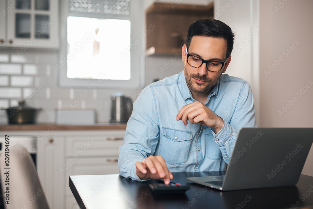 Young accountant count on calculator at home. Young accountant count on calculator at home.