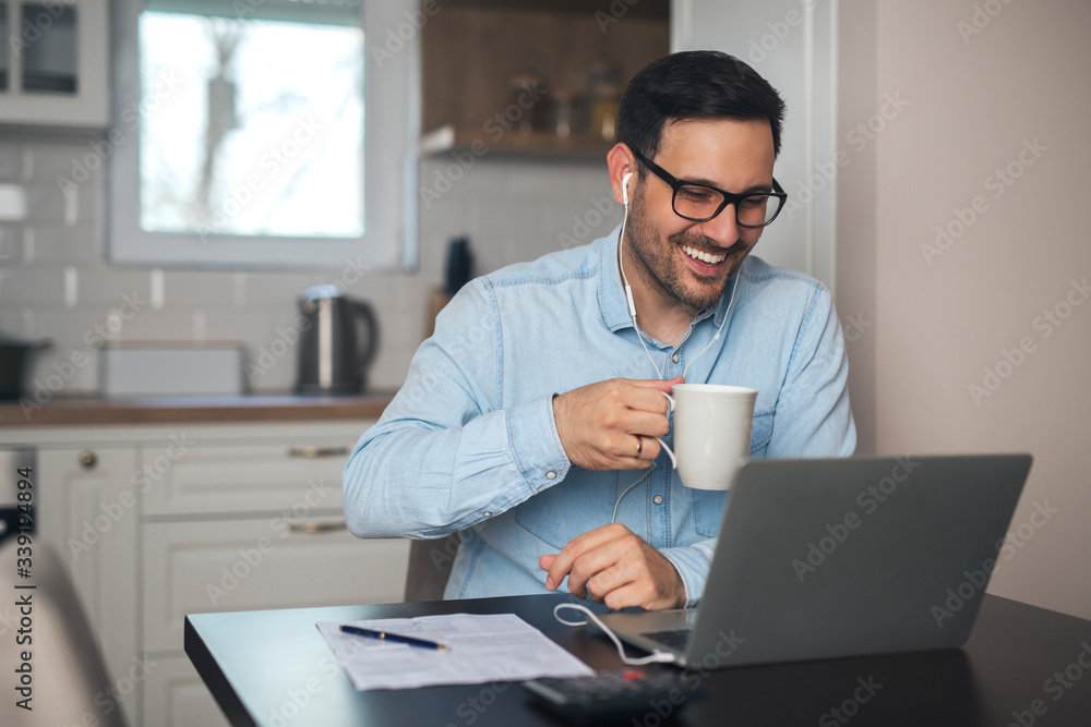 Man drinks coffee while having a video call on laptop. Man drinks coffee while having a video call on laptop.