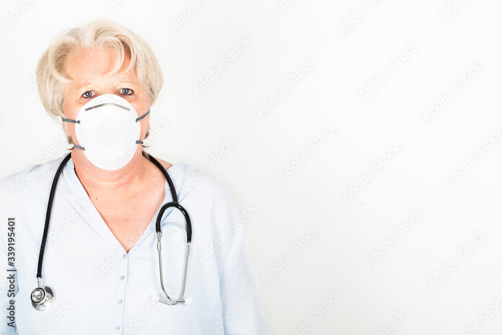 Close-up of a mature caucasian doctor with blond hair wearing a face mask to protect herself from coronavirus infection or air pollution. With stethoscope