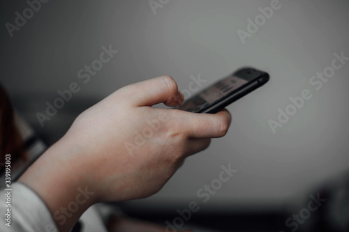 Young girl holds phone in hand sitting in room