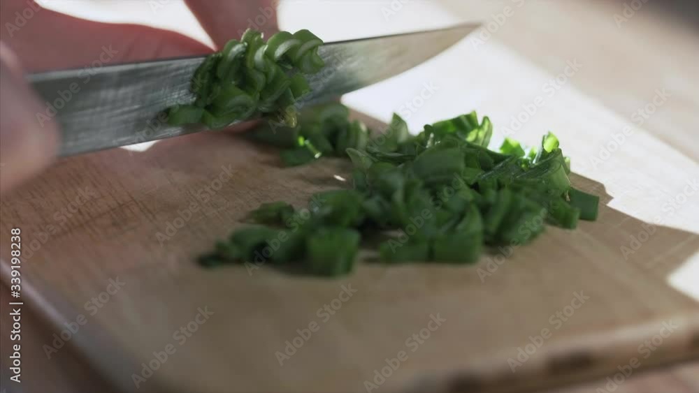 Woman cuts green onion on the kitchen Woman cuts green onion on the kitchen