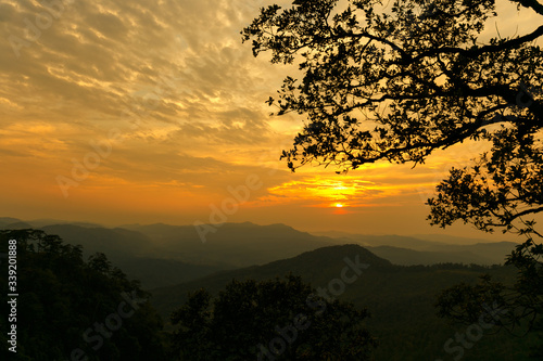 A silhouette view of tree and mountain in sunset time.