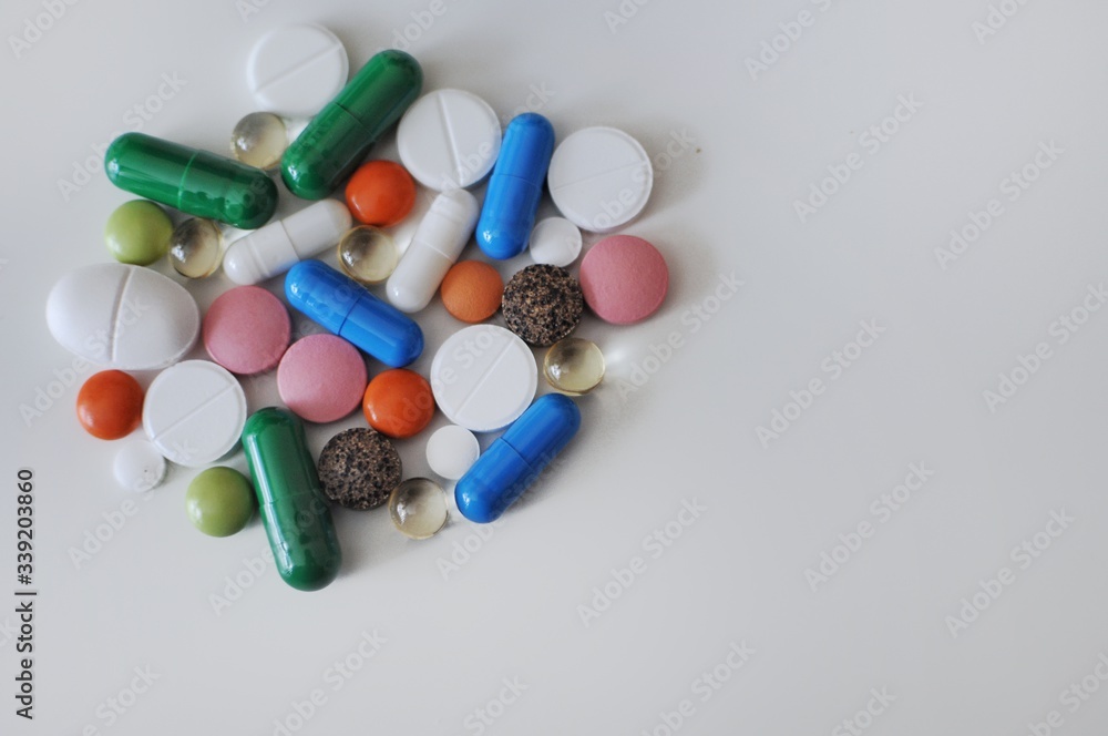 Many colorful pills on white background. Treatment against COVID-19 and others. Many colorful pills on white background. Treatment against COVID-19 and others.