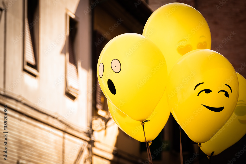 Yellow Emoji balloons floating at a street party in Senigallia, Le Marche, Italy