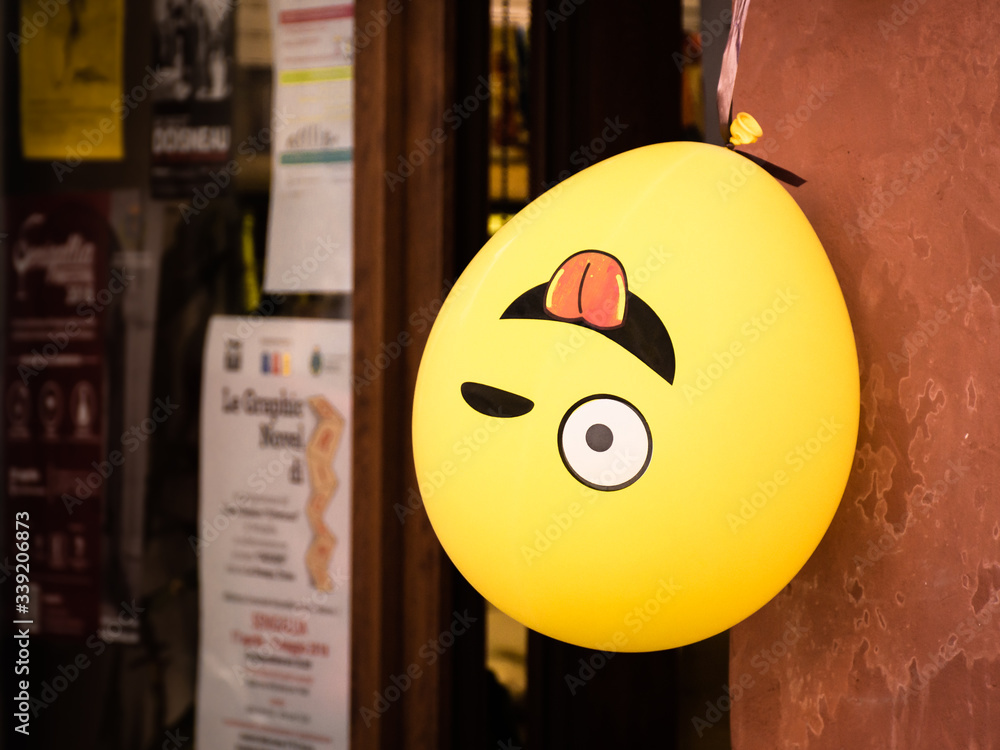 Winking emoji balloon hangs upside down outside a shop in Senigallia, Le Marche, Italy