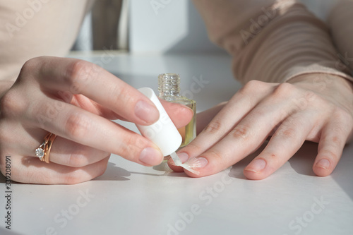 Woman giving herself elegant manicure applying polish on nails at home. Beauty treatment and hand care. Manicure at home. Quarantine.