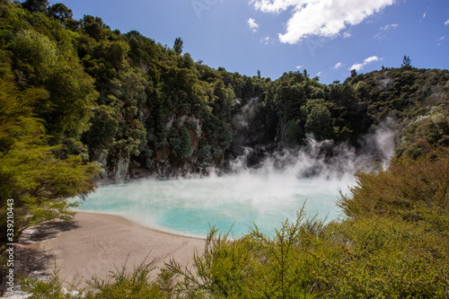 Fototapeta Naklejka Na Ścianę i Meble -  
The rich mineral laden water that bursts from the earths molten core produced this vivid blue pond on the edge of a silica terrace. Waimangu Volcanic Valley, New Zealand

