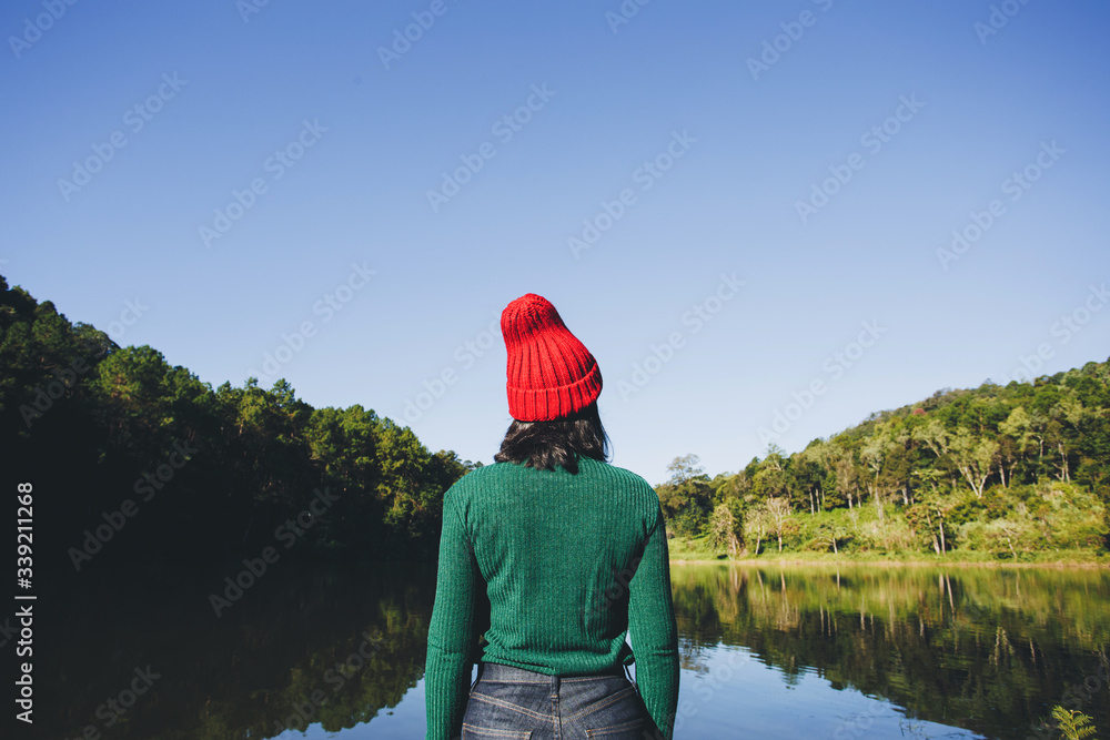 Beautiful young woman looking view of the mountains landscape at lake, Pang Oung, Thailand. Vacation concept