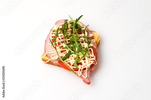 Sandwich of bread for toast, sturgeon, tomatoes, arugula, cheese and mayonnaise on a white background view from the top flat lay