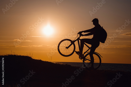 Silhouette of cyclist in motion at beautiful sunset.
