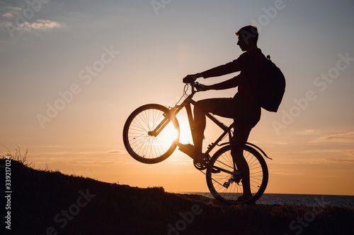 Silhouette of cyclist in motion at beautiful sunset.