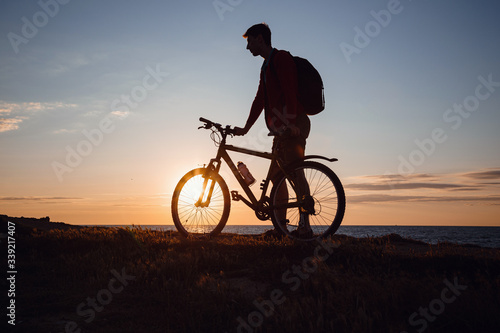 Silhouette of cyclist in motion at beautiful sunset. © YURII Seleznov