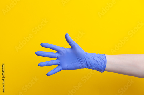 Doctor hand in medical lilac rubber glove showing palm, five fingers