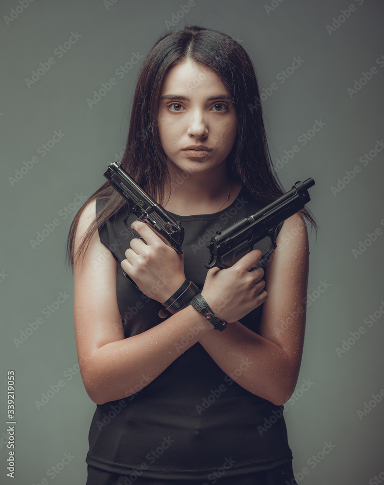 Shot of a sexy military woman posing with guns Shot of a sexy military woman posing with guns