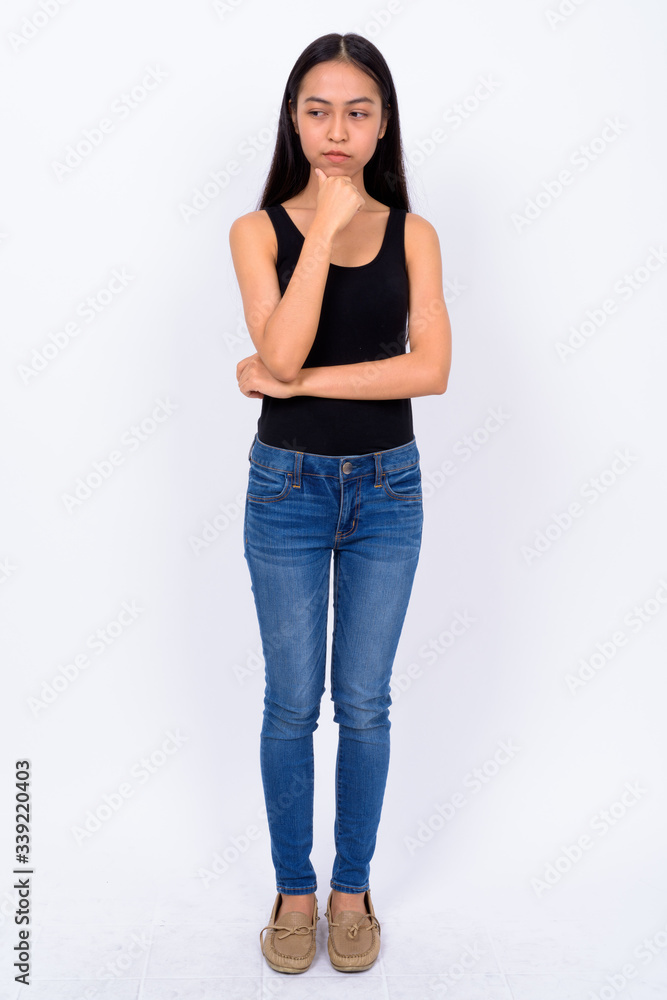 Full body shot of young Asian woman thinking Full body shot of young Asian woman thinking