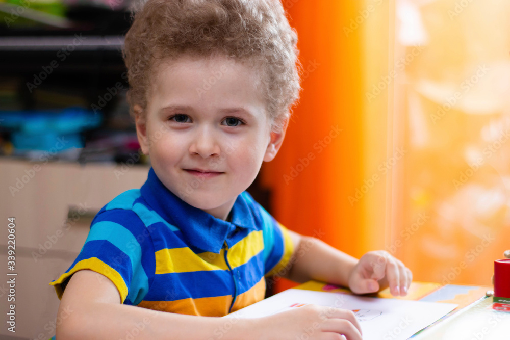 Little boy draws at a table at home. Quarantine classes at home Little boy draws at a table at home. Quarantine classes at home