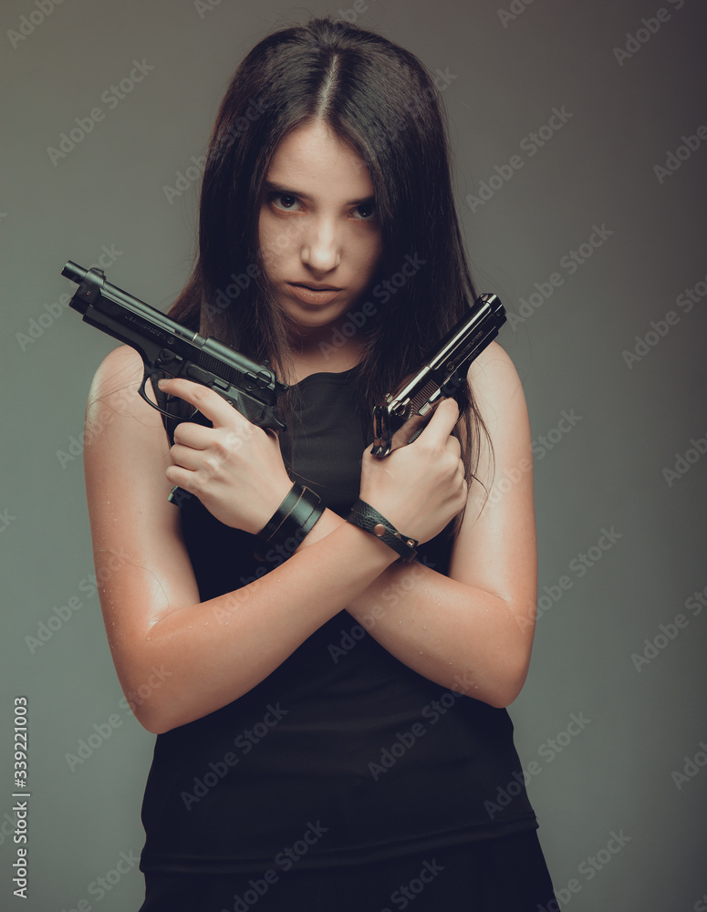 Shot of a sexy military woman posing with guns Shot of a sexy military woman posing with guns